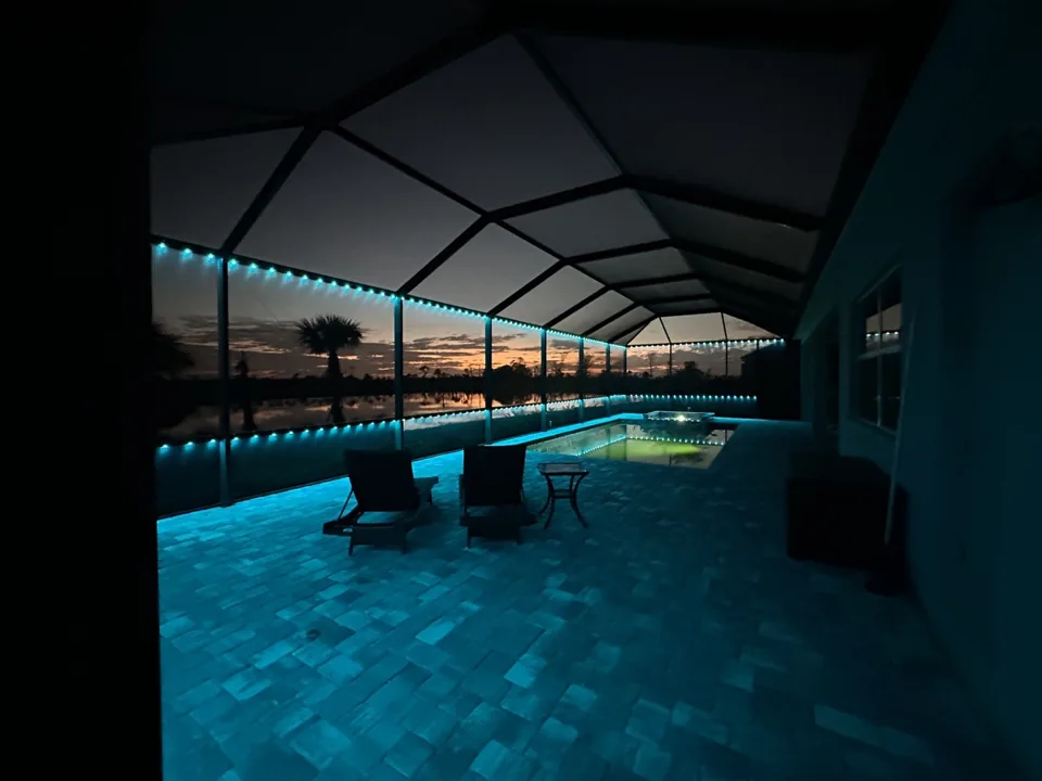 Lakefront pool cage in cyan at dusk