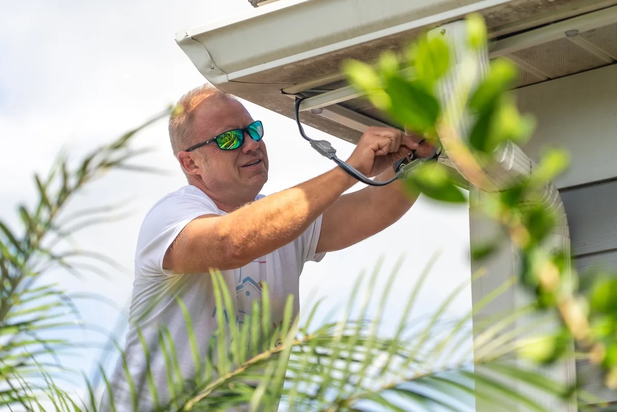 Installer fitting color-matched channel under a soffit
